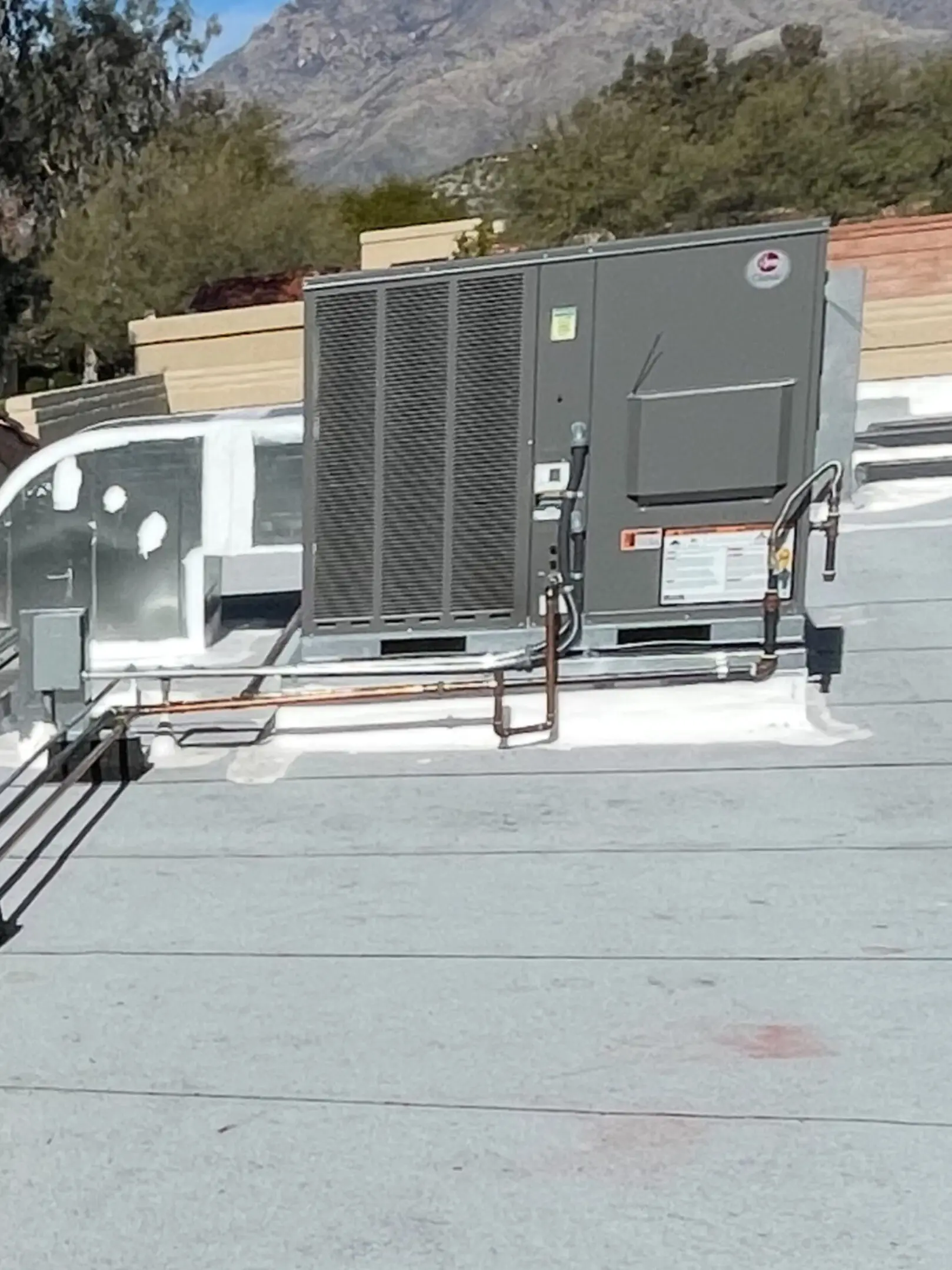 A large air conditioner on the roof of a building.