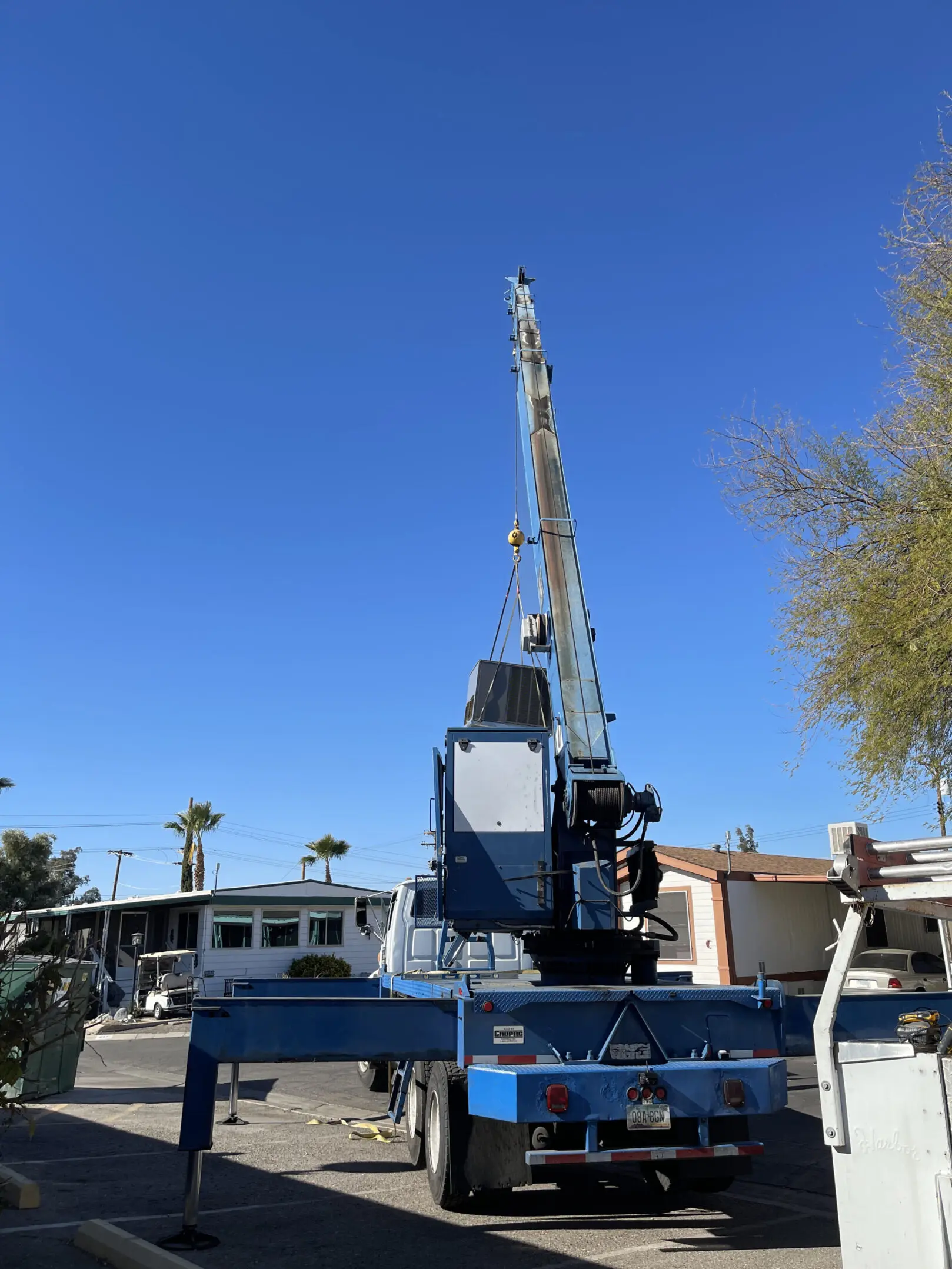 A crane is in the middle of a parking lot.