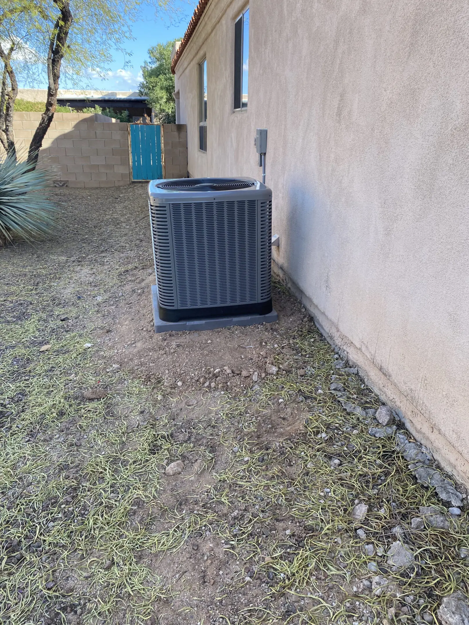 A black air conditioner sitting outside of a house.