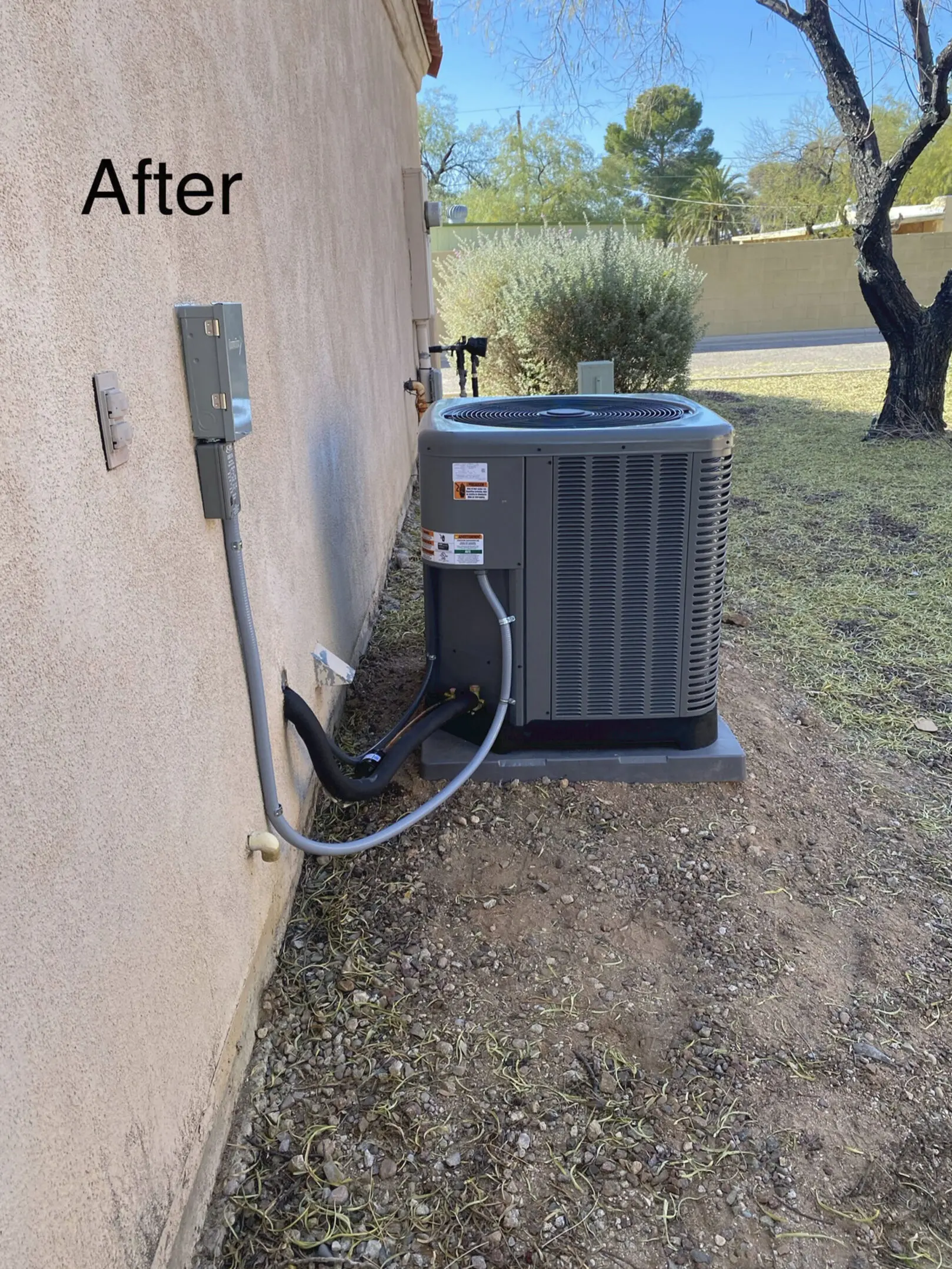 A picture of an air conditioner outside on the ground.