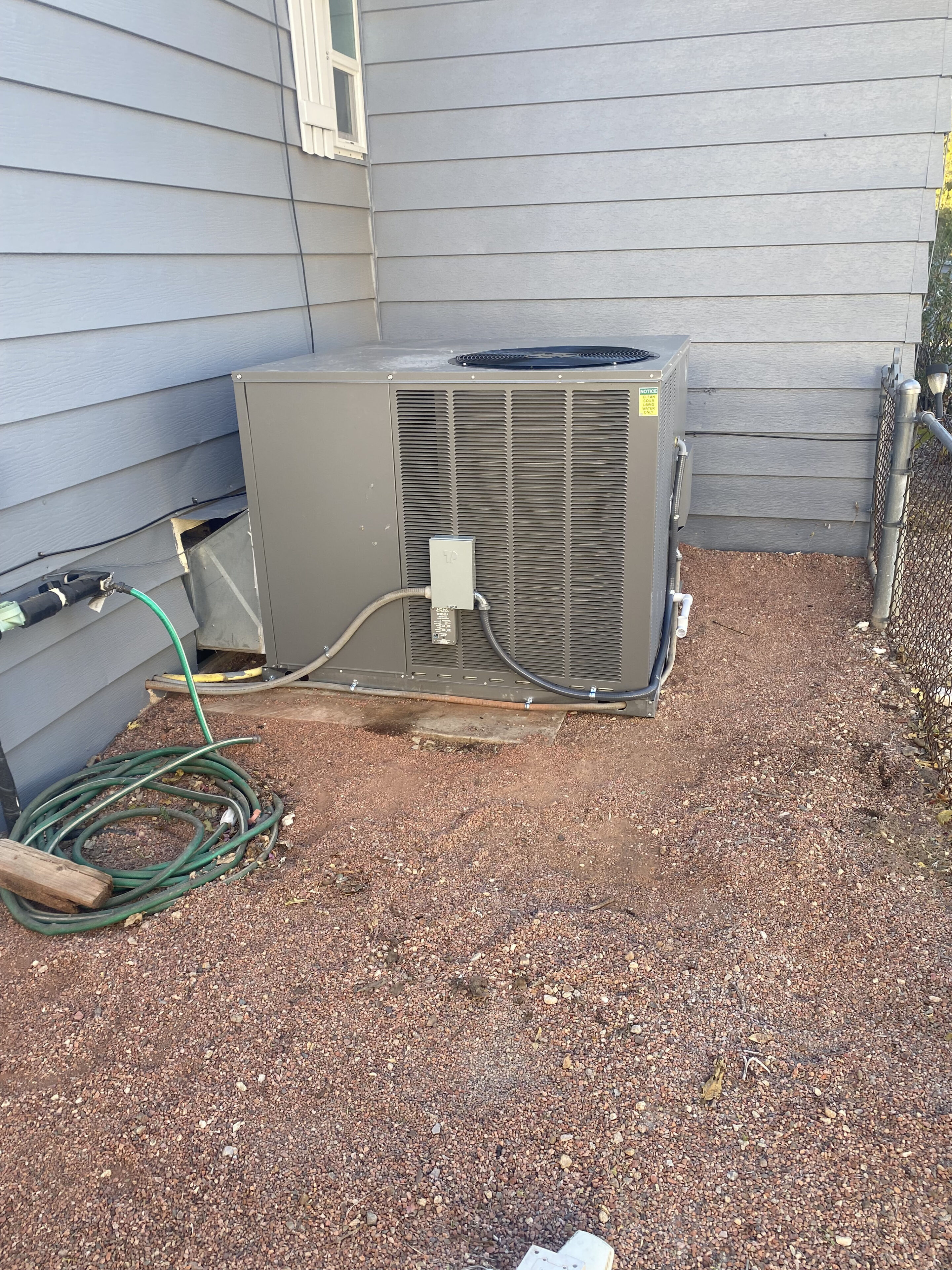 A dirty air conditioner unit sitting outside of a house.